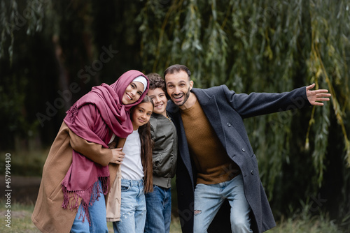 Excited muslim family looking at camera outdoors photo