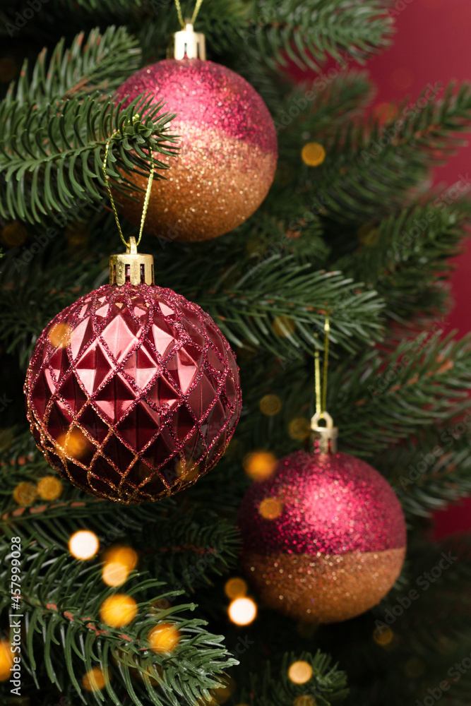 Closeup of fir tree with New Year decorations. Colorful gold and red Christmas ornaments. Closeup of fir tree with New Year decorations. Colorful gold and red Christmas ornaments.