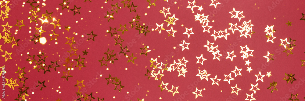Banner with metallic gold colored stars confetti scattered on a red background. Banner with metallic gold colored stars confetti scattered on a red background.