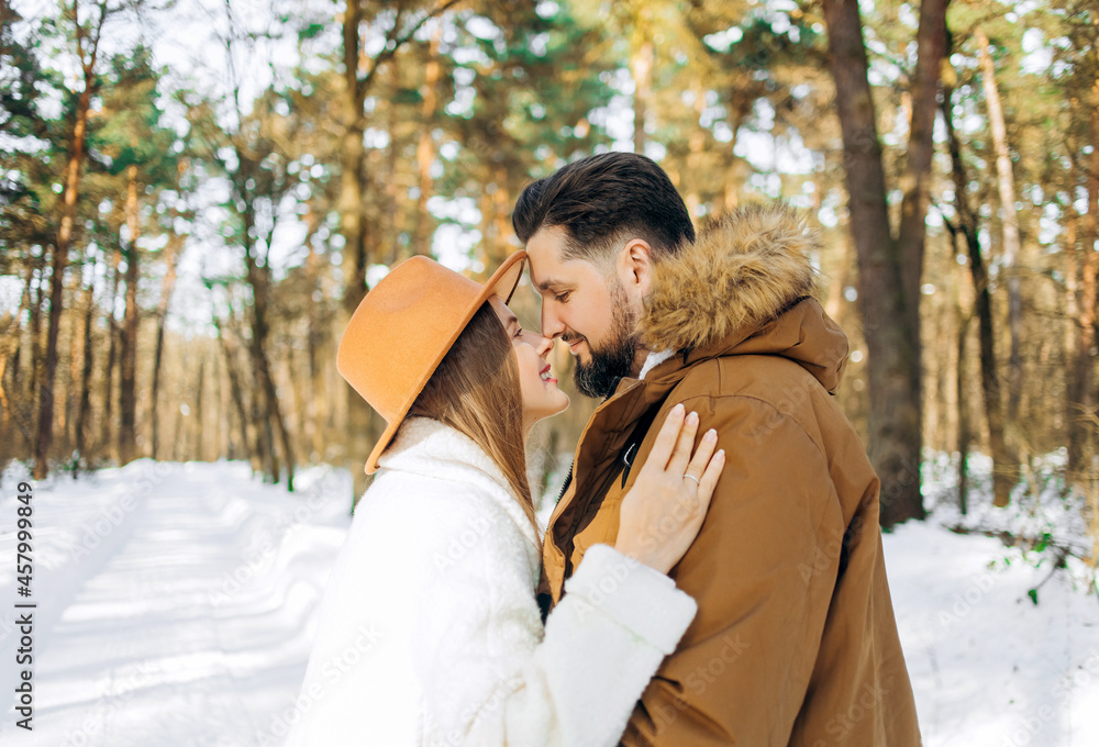 Husband and wife hug each other in the winter forest Husband and wife hug each other in the winter forest