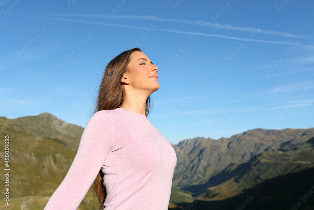 Casual woman breathing fresh air in a high mountain Casual woman breathing fresh air in a high mountain