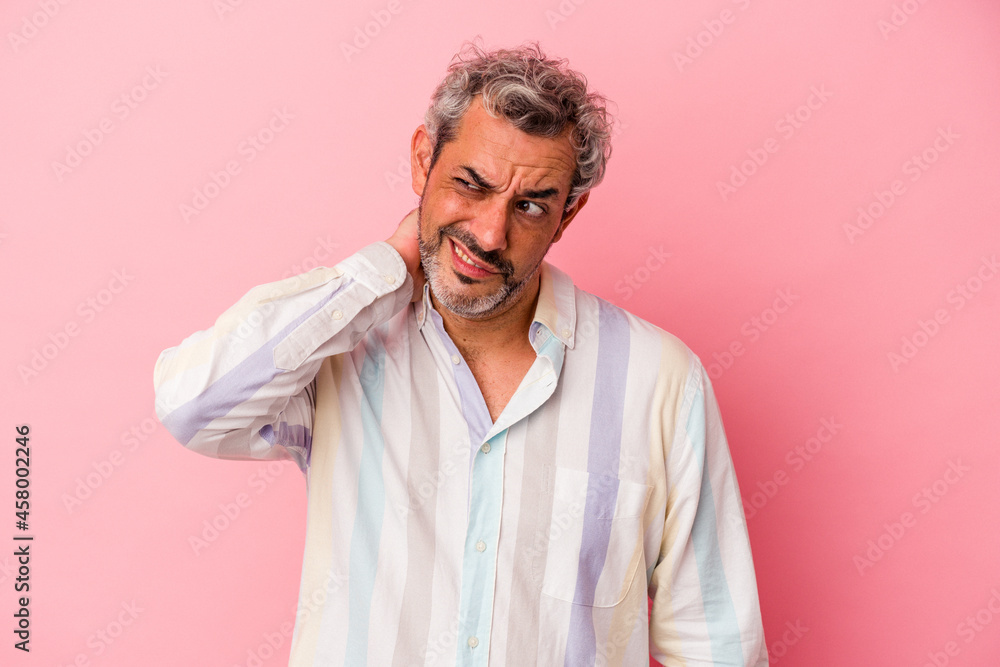 Middle age caucasian man isolated on pink background touching back of head, thinking and making a choice. Middle age caucasian man isolated on pink background touching back of head, thinking and making a choice.