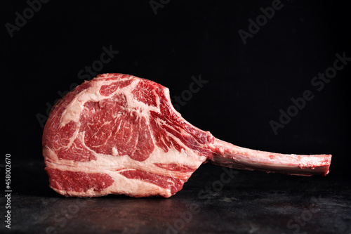 Fresh tomahawk steak on old board