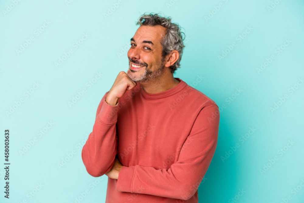 Middle age caucasian man isolated on blue background  smiling happy and confident, touching chin with hand.