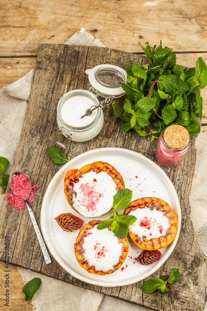 Grilled peach with yogurt, mint, and sweet pink sugar. Useful breakfast concept, healthy food Grilled peach with yogurt, mint, and sweet pink sugar. Useful breakfast concept, healthy food