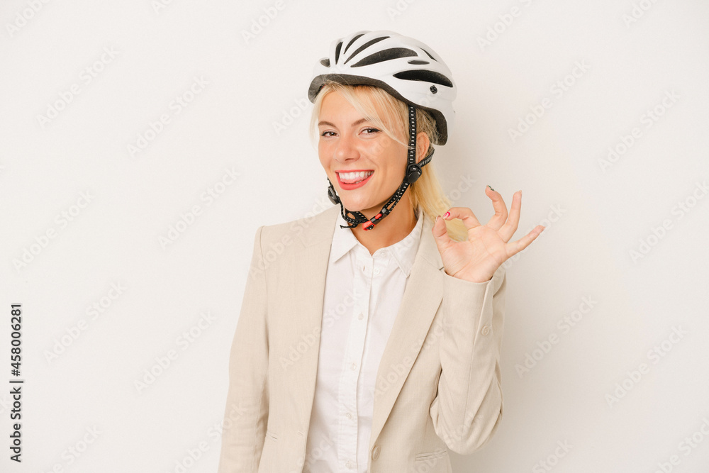 Young business Russian woman holding bike helmet isolated on white background cheerful and confident showing ok gesture. Young business Russian woman holding bike helmet isolated on white background cheerful and confident showing ok gesture.