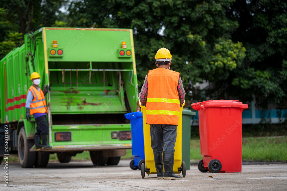 Worker of recycling garbage collector truck loading waste and trash bin