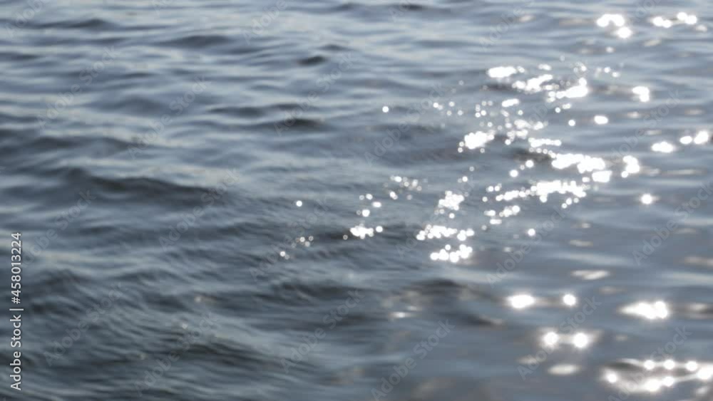 Sunlight shines on the blue sea or ocean surface. Water background with bokeh Sunlight shines on the blue sea or ocean surface. Water background with bokeh