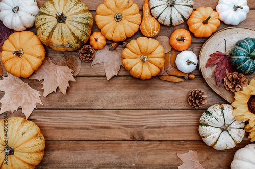 Thanksgiving flat lay. Pumpkins, autumn leaves on rustic wood with space for text. Happy Thanksgiving and Halloween template. Hello Autumn. Harvest