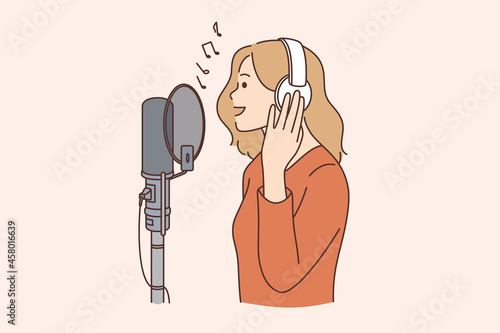 Singer, blogger and radio program concept. Young smiling woman in headphones standing singing song or talking on microphone in studio vector illustration 