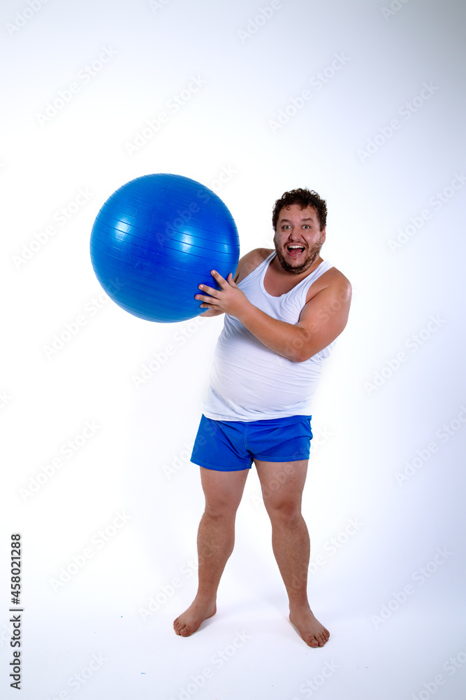 Funny fat man training with a fitness ball. Adult guy on a white background. Copy space. Active sports with a diet.	
