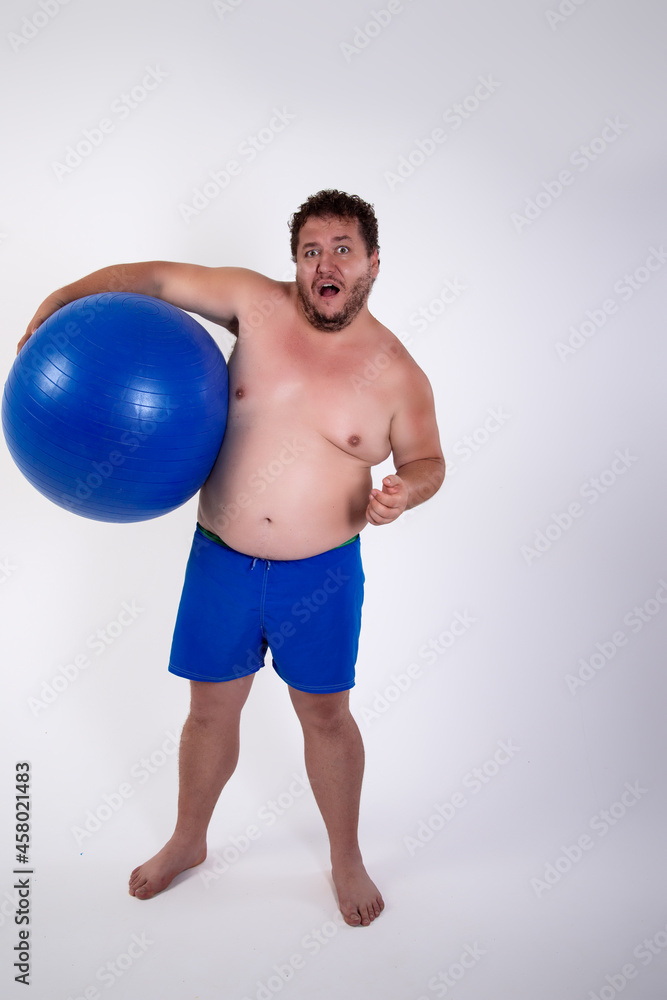 Funny fat man training with a fitness ball. Adult guy on a white background. Copy space. Active sports with a diet.
Funny fat man training with a fitness ball. Adult guy on a white background. Copy space. Active sports with a diet.