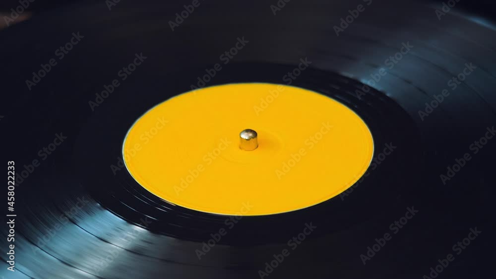 Black Vinyl Retro Record Rotating Plate with Yellow Label on Old DJ Turntable Player. Party and Popular Disco Trends on Vintage Spinning Record Close Up. Side View Black Vinyl Retro Record Rotating Plate with Yellow Label on Old DJ Turntable Player. Party and Popular Disco Trends on Vintage Spinning Record Close Up. Side View