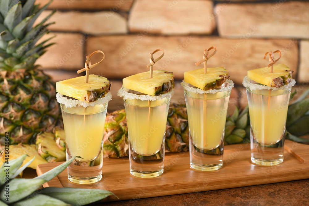  Double shots of tropical tequila with pineapple juice. This is definitely going to be a great party for Cinco de Mayo! - obrazy, fototapety, plakaty 
