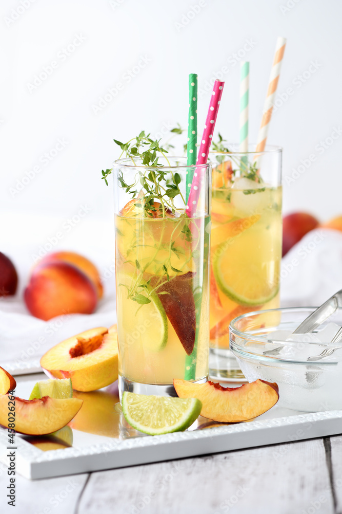 Fototapeta premium Peach summer cocktail. Refreshing organic non-alcoholic drink, lemonade with ripe nectarine, thyme and lime 