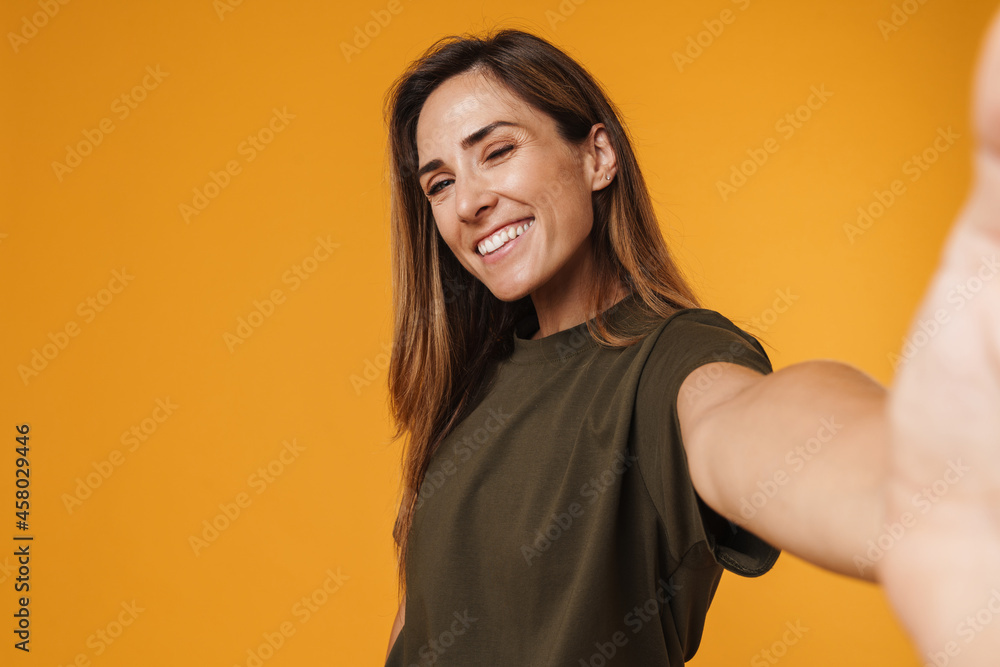 European ginger woman in t-shirt smiling while taking selfie photo European ginger woman in t-shirt smiling while taking selfie photo