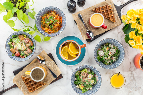 Breakfast food table brunch set with freah salad and waffle on marble background