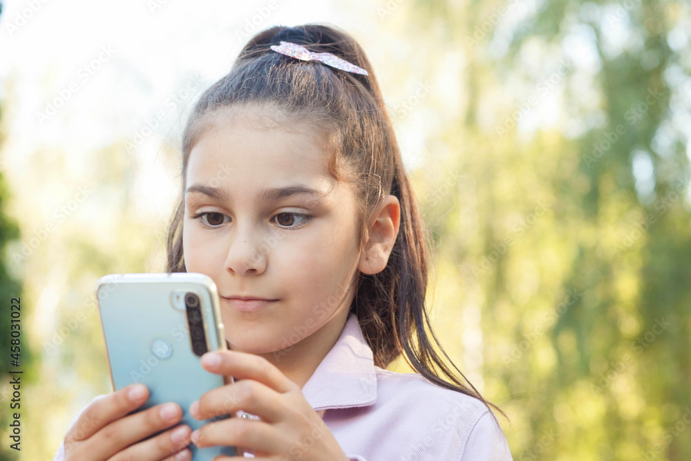 Happy child girl with phone outdoors. Gagets consept Happy child girl with phone outdoors. Gagets consept