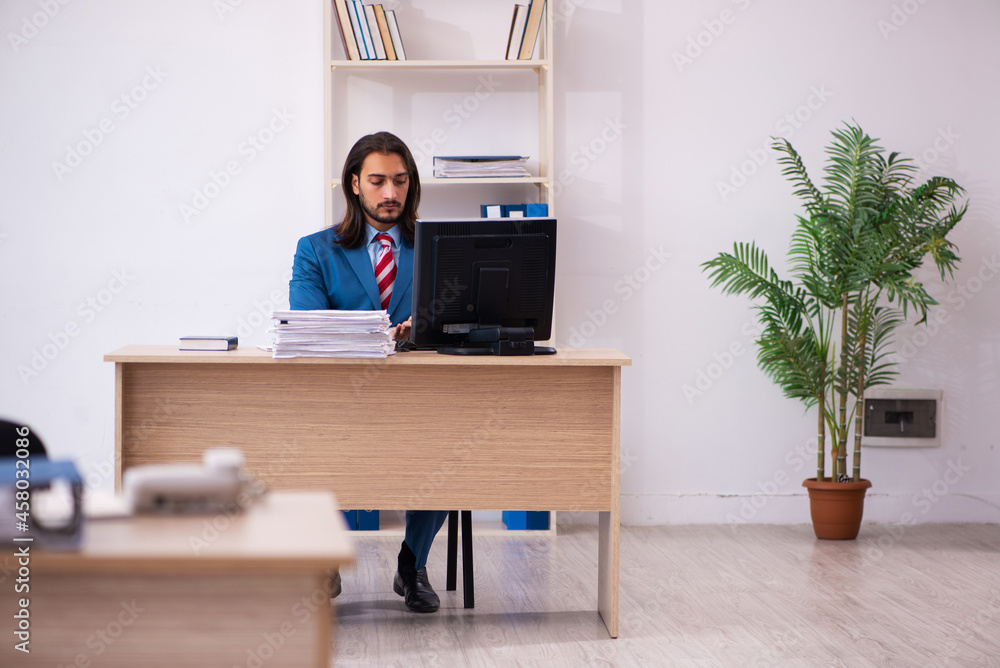 Fototapeta premium Young male employee working at workplace
