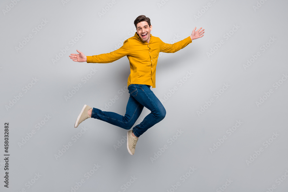 Full length body size view of attractive cheerful man jumping resting having fun isolated over grey color background