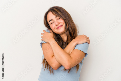 Young caucasian woman isolated on white background hugs, smiling carefree and happy.