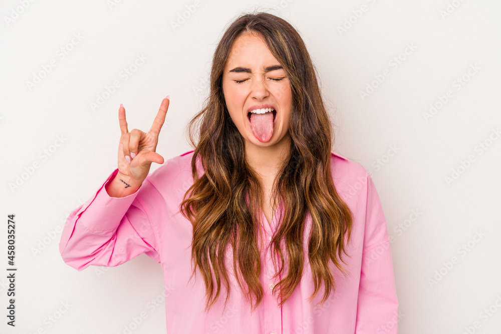 Young caucasian woman isolated on white background showing rock gesture with fingers Young caucasian woman isolated on white background showing rock gesture with fingers