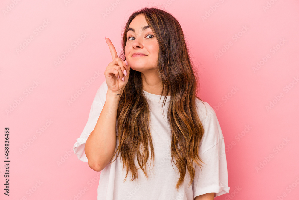 Young caucasian woman isolated on pink background showing number one with finger. Young caucasian woman isolated on pink background showing number one with finger.