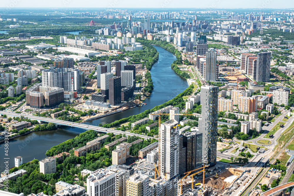 Fototapeta premium Moscow, Russia - June 5, 2021: Panoramic aerial view of the city of Moscow, the Moskva river, bridges, residential buildings, skyscrapers on a sunny summer day
