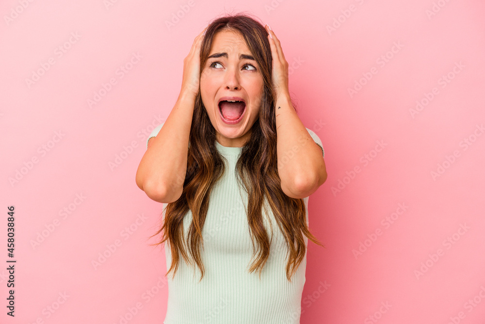 Young caucasian woman isolated on pink background covering ears with hands trying not to hear too loud sound. Young caucasian woman isolated on pink background covering ears with hands trying not to hear too loud sound.