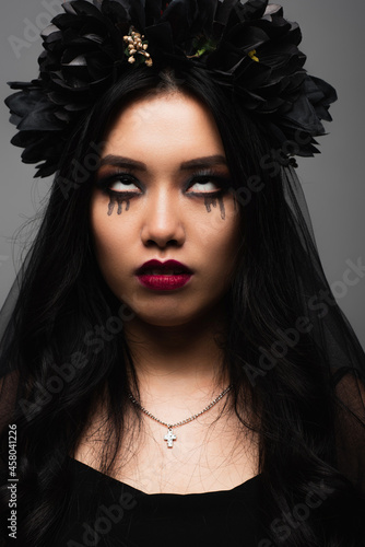 Fototapeta Naklejka Na Ścianę i Meble -  scary asian woman in vampire halloween costume and makeup grimacing isolated on grey