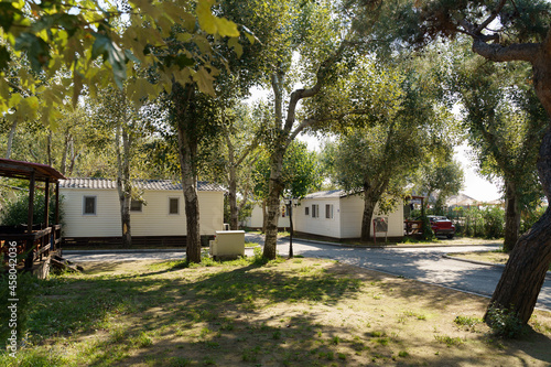 Vacation mobile houses on a campsite with trees around. High quality photo