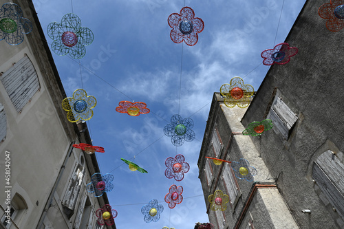 Décoration avec des fleurs en plastique de différentes couleurs dans une rue de Castelnaudary