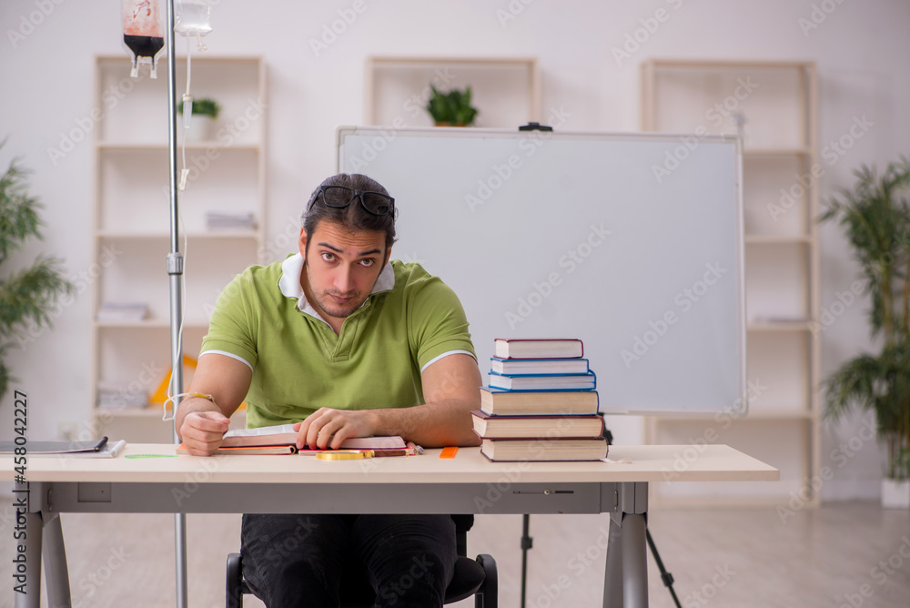 Young sick male teacher student in blood transfusion concept Young sick male teacher student in blood transfusion concept