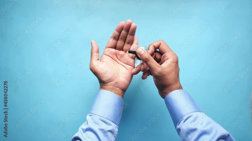 Using hand sanitizer liquid on blue background Using hand sanitizer liquid on blue background