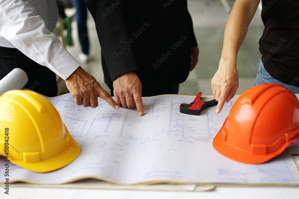 Construction Ideas: Engineers, architects and homeowners discuss construction from blueprints placed on a white table. The orange and yellow engineer helmets were taken off and placed on the table.
Construction Ideas: Engineers, architects and homeowners discuss construction from blueprints placed on a white table. The orange and yellow engineer helmets were taken off and placed on the table.