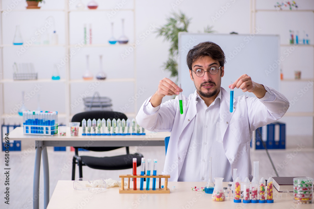 Young male chemist in drugs synthesis concept Young male chemist in drugs synthesis concept
