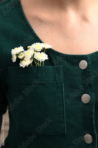 Woman wearing shirt with flowers in pocket, closeup photo