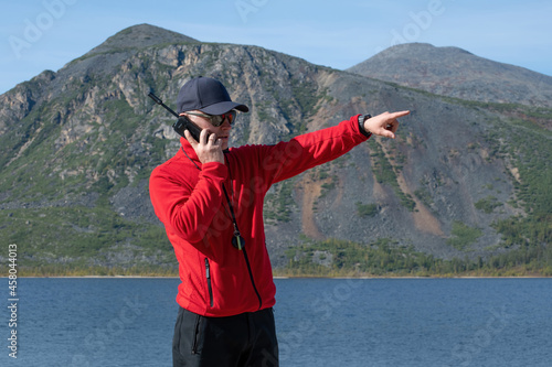 man talking on a satellite phone in the mountains
