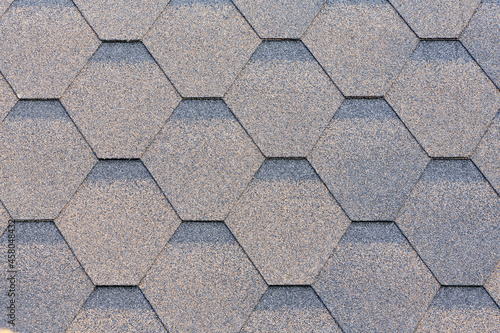 Flexible roof tiles. Roof covering materials. Asphalt shingle. Decorative bitumen shingles texture background. Close up top view.