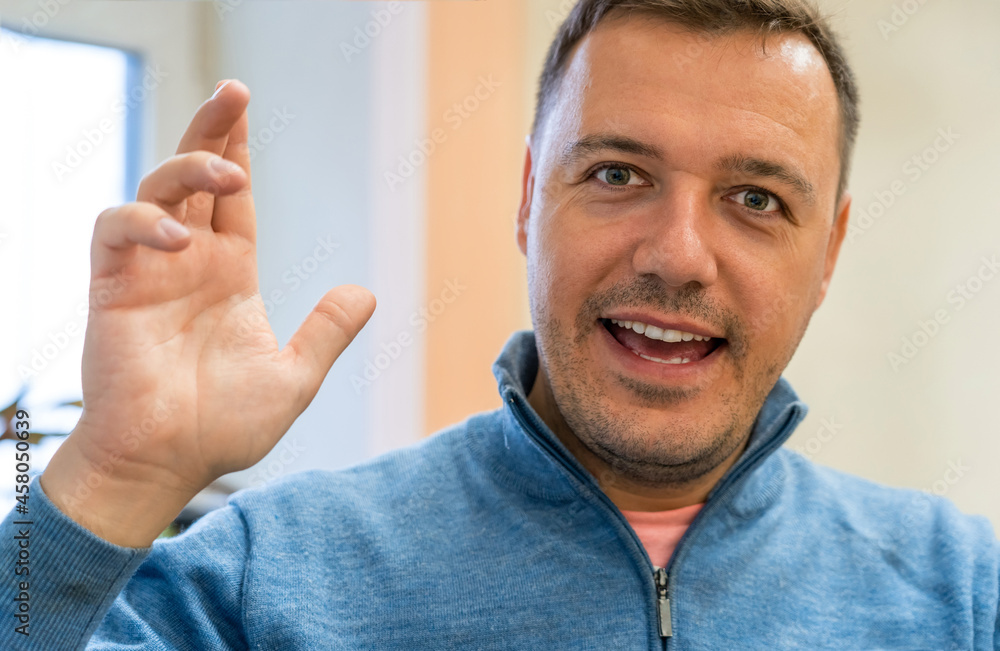 Millennial man waving hand, making hello gesture and looking at camera. Guy making video call indoors Millennial man waving hand, making hello gesture and looking at camera. Guy making video call indoors