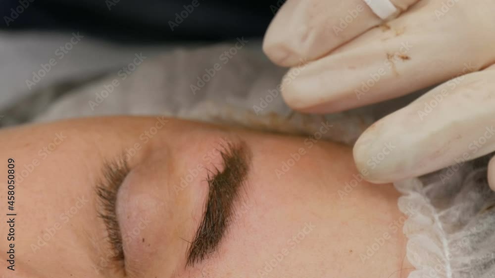 The eyebrow shape correction master applies a special dark pigment under the skin to emphasize the density of the eyebrows. Modern cosmetic procedures, eyebrow microblading, permanent makeup, tattoo The eyebrow shape correction master applies a special dark pigment under the skin to emphasize the density of the eyebrows. Modern cosmetic procedures, eyebrow microblading, permanent makeup, tattoo