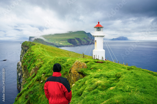 Tourist visiting the landmark of Mykines Island - Holmur Lighthouse photo