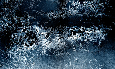 Frozen winter window. Window frozen glass, ice crystals. Beautiful Hoarfrost pattern, rime on black background. Snow, Christmas or New Year backdrop for screen mode use. 