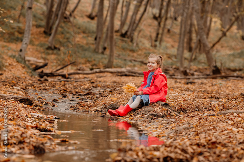 a little girl in a coat and red rubber boots walking in the autumn forest. High quality photo © КРИСТИНА Игумнова