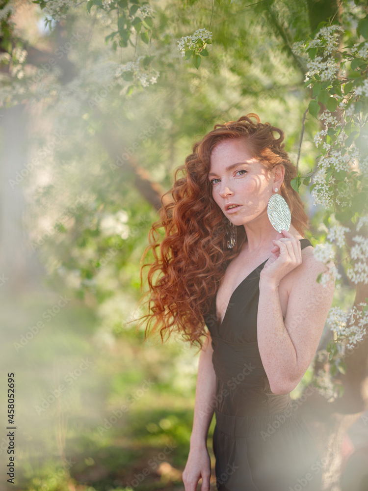 Redhead woman in black suit walks in spring city Redhead woman in black suit walks in spring city