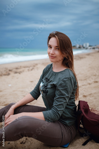woman enjoying sea air on autumn beach before thunderstorm