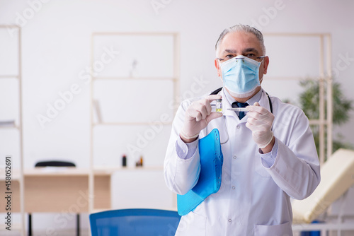 Old male doctor working in the clinic