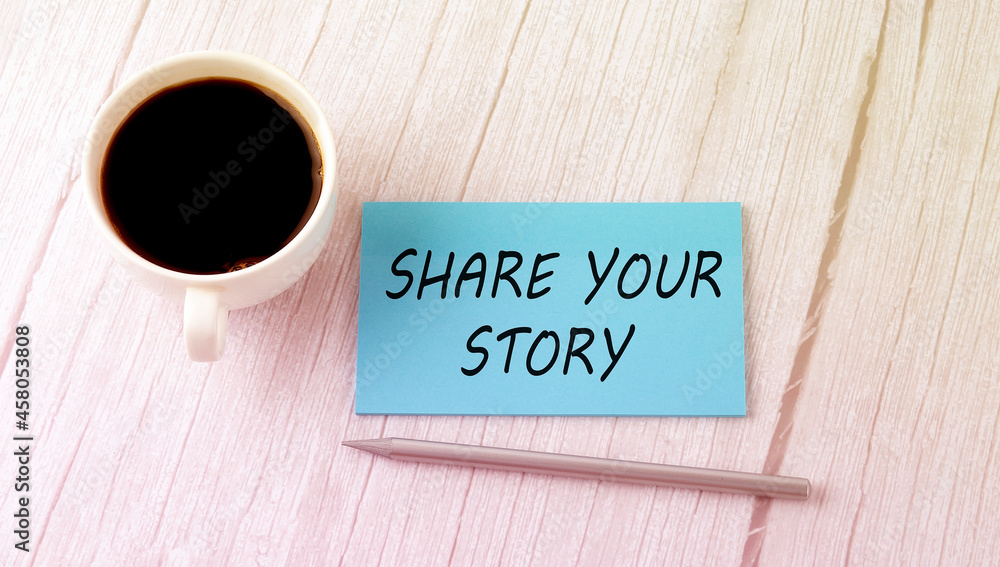 SHARE YOUR STORY text on the blue sticker with cofee and pen SHARE YOUR STORY text on the blue sticker with cofee and pen