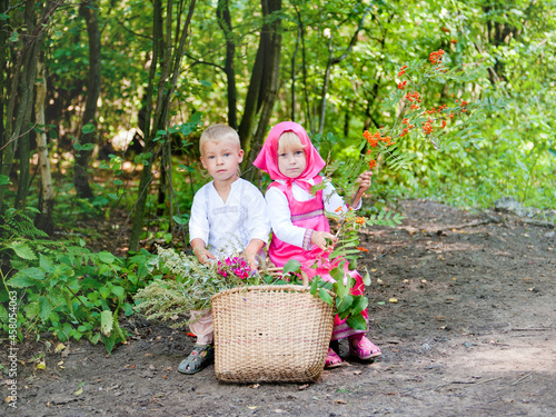 little boy and girl in national costumes in a village in Russia