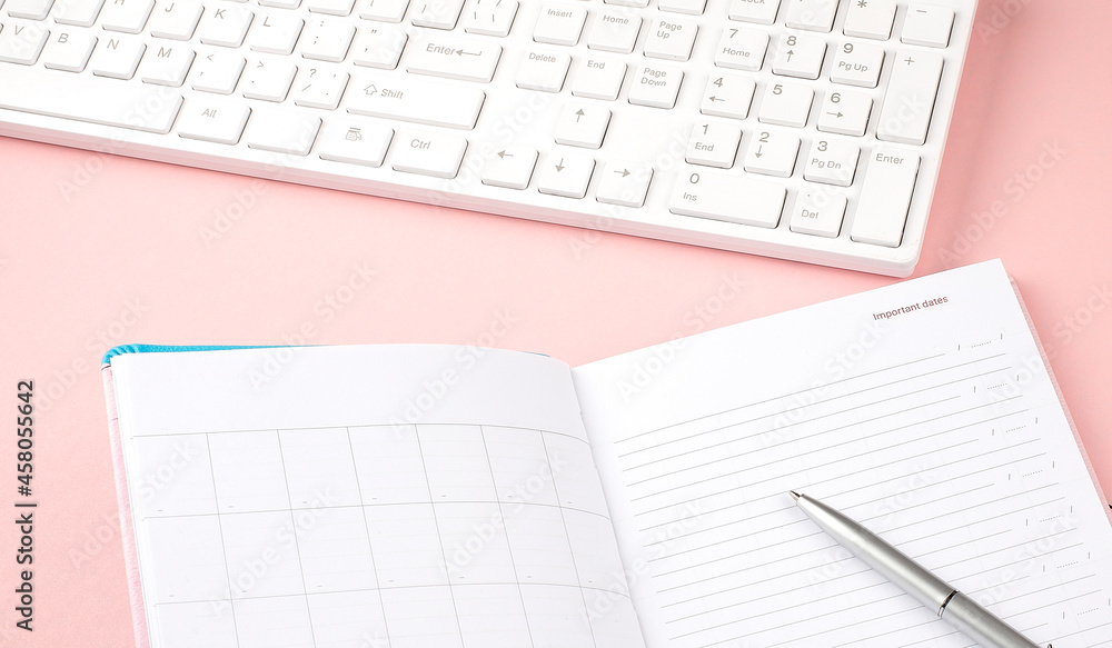 Pink pastel woman office desk with keyboard and diary.Top view with copy space Pink pastel woman office desk with keyboard and diary.Top view with copy space